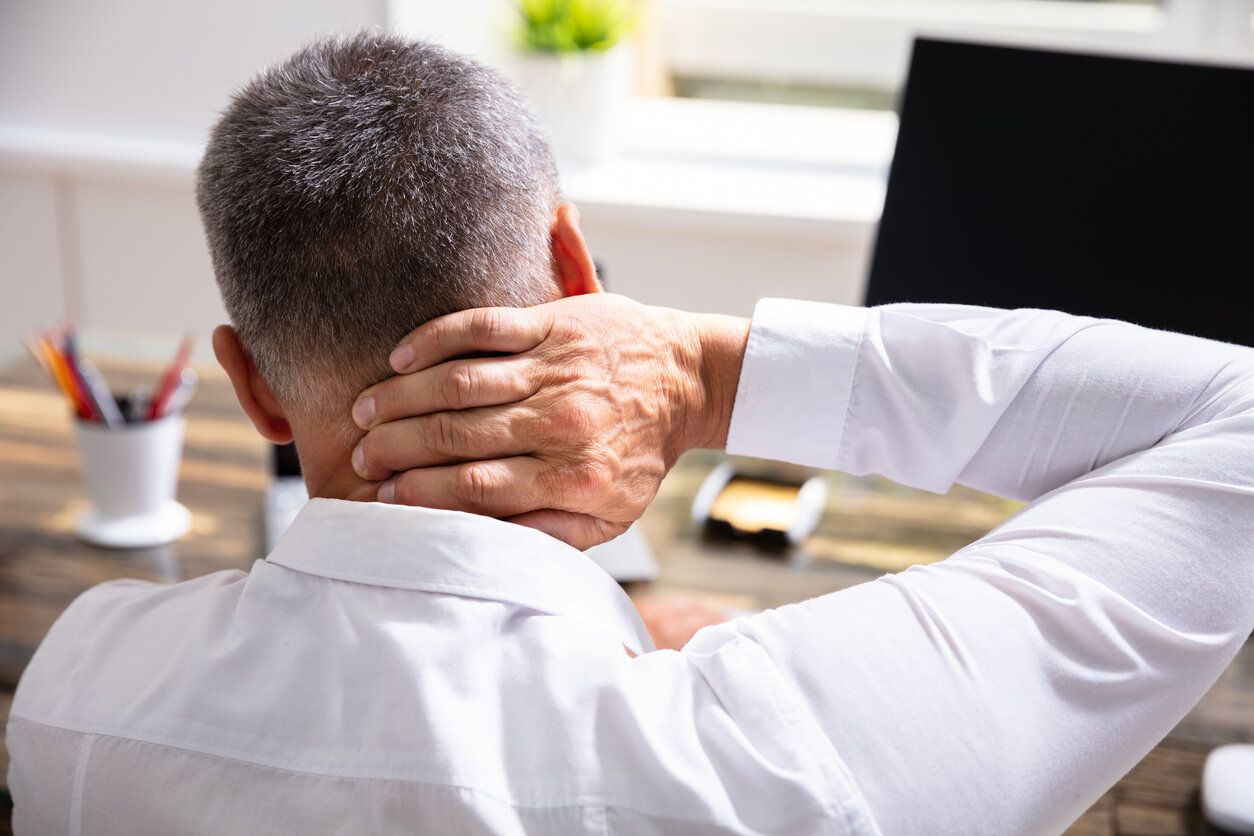 Young Businessman Suffering From Neck Pain At Office